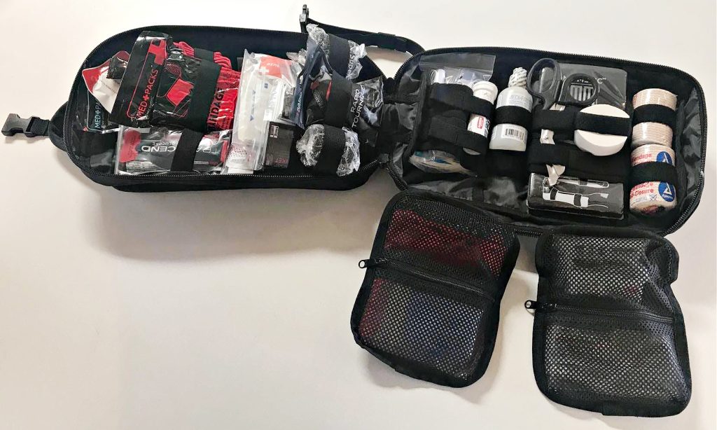 MyMedic MyFAK Large clamshell bag, open, two drop-out bags with wound care supplies and OTC medications. Pockets and elastic bands hold the rest of the first aid supplies.